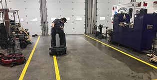 Man cleaning the service shop's floors