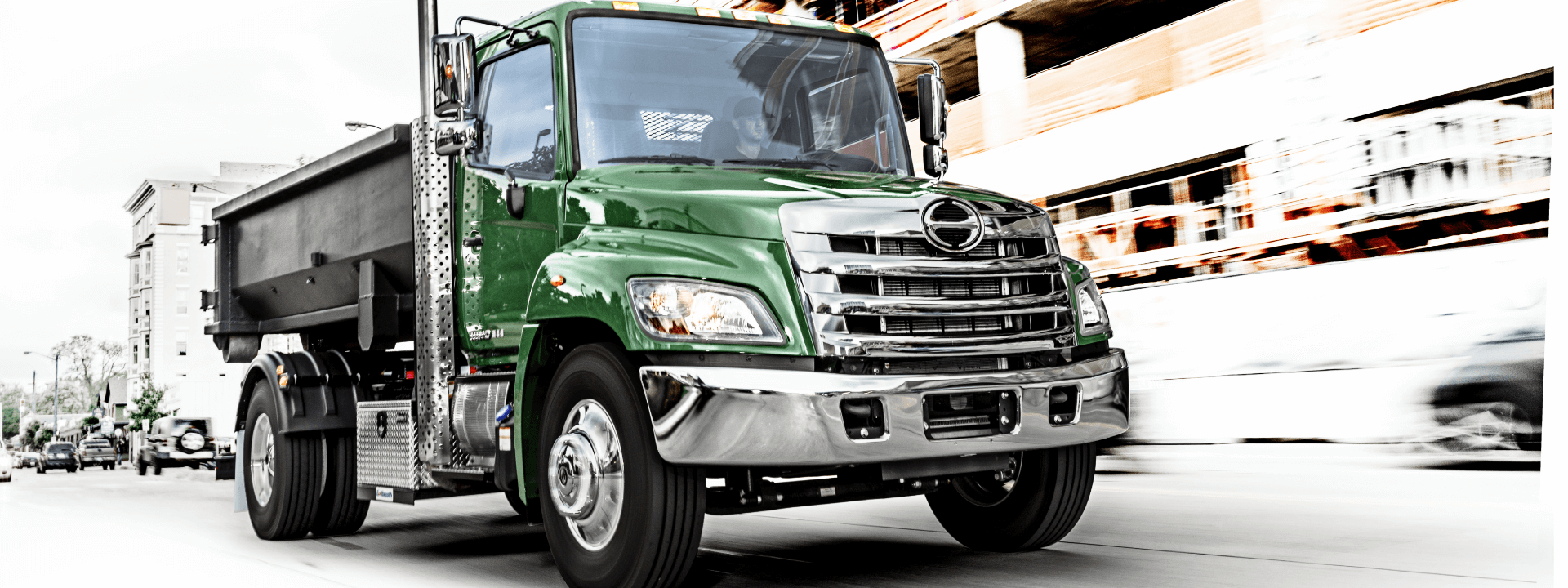 Green Hino truck on a city street
